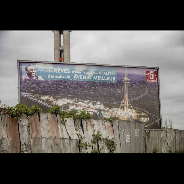 <i>‘Cinq Chantiers’ billboard, Place de l’échangeur, municipality of Limete, Kinshasa</i>, 2013<br>
Inkjet print on Epson baryta Photo Rag 315g<br>
100 x 150 cm / 39 13/8” x 59” <br>
Edition: 5 + 2 AP