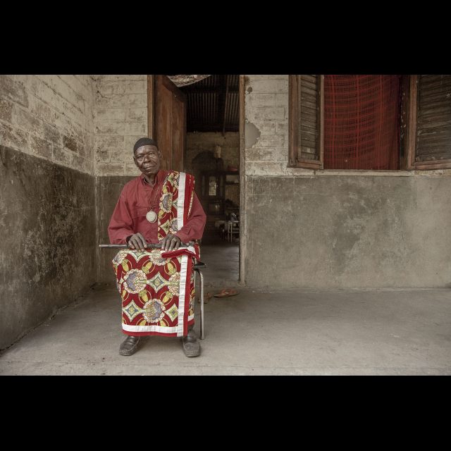 <i>Teke Chief Mikala, sub-chief of Kingati, at his home n the neighborhood of Kinkole, municipality of Nsele.</i> March 2013.<br>
Inkjet print on Epson baryta Photo Rag 315g<br>
80 x 120 cm / 31 1/2” x 47 1/4” <br>
Edition: 5 + 2 AP