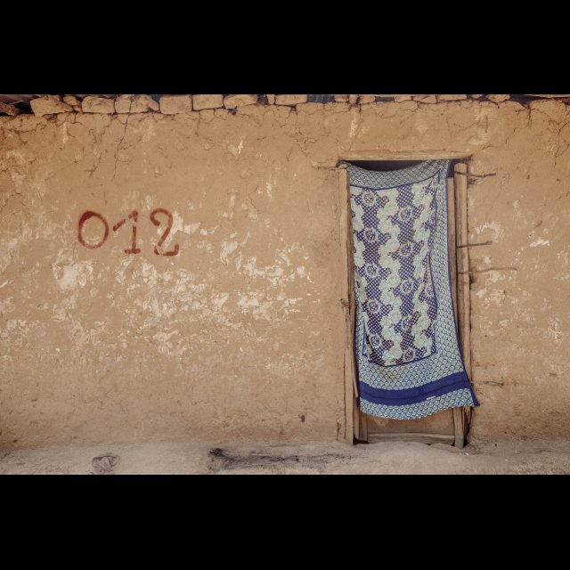 <i>Houses marked for demolition at the Kiswishi site. Three villages will have to make way for the new planned city. Lubumbashi 2013</i><br>
Inkjet print on Epson baryta Photo Rag 315g<br>
80 x 120 cm / 31 1/2” x 47 1/4”<br>
Edition: 5 + 2 AP