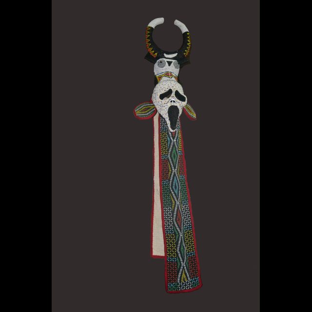 Series: Visages de masques <br>
Bamileke Elephant-Scream Mask<br>
Wood, pigment, fiber, beads, cowrie, shells, textile<br>
166 cm x 22 cm x 27 cm/ 56" x 8 ¼" x 10 ¾"