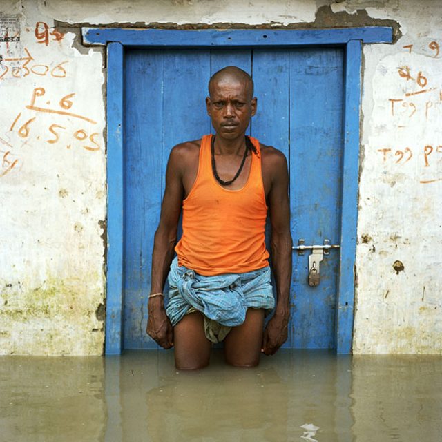 Bindeshwar Sahni outside his flooded house in Pir-muhammadpur village on the banks of the river Ganda which was totally submerged by the recent flooding. Most people in this community are displaced and staying in a camp set up by the Muzaffarpur Development Agency a local partner of the charity Action Aid. This is one of many communities in the province of Bihar devastated by the worst floods in living memory which have submerged thousands of villages and huge swathes of farmland in northern India, Bangladesh and Nepal. In Bihar alone more than 515 people have perished and more than 16 million people have been affected. At least two million people have been displaced and are forced to live outdoors on higher ground. These floods were caused by the sort of extreme weather that scientists have been predicting will become more frequent as a result of global warming.