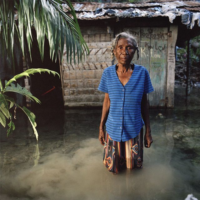 Marie Miracle Andris aged 75 stands in front of her flooded house in Marigot in southeast Haiti. Her house was flooded and damaged by Hurricane Gustav. During the hurricane season of 2008 Haiti was subjected to four destructive hurricanes in the space of twenty days. This increasing severity and quantity of hurricanes is one of the effects of climate change, which scientists have been predicting. Haiti is extremely vulnerable to these hurricanes due to the uncontrolled deforestation of its mountains and hillsides for the production of charcoal. Hence the mountains do not hold rainwater resulting in widespread flooding. “I lost a lot of things. I had a table and a cupboard for crockery and I had a refrigerator. They were all destroyed when the tree fell. Now if you asked me for some water, I would have nothing to serve it in, because there’s nothing left.”<br>
Chromogenic print on Fuji Crystal Archive<br>
27 1/2” x 27 1/2 / 48” x 48”; Edition: 5 + 2 AP
<br>
70 x 70 cm / 122 x 122 cm; Edition: 3 + 2 AP