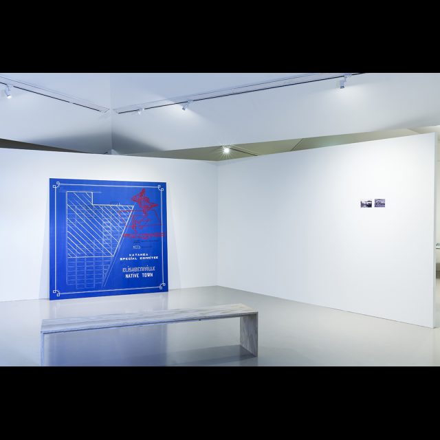 Installation of Blueprint of Sanitary Cordon and Historical photographs of housing and blasted landscape in Lubumbashi, Katanga Province, DRC.<br>
Framer Framed, Amsterdam. © Eva Broekema