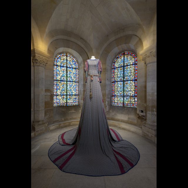 Series: Les Grand Robes Royales<br>
Height: 3 m / 9 ft<br>
Installation view, Cathedral of St. Denis, 2016. <br>
The coat and the overcoat are in printed muslin. The belt is made up of twisted beaded fabrics and decorated with rings.<br>
Collaboration: Dressmakers of the Floréal neighborhood of Saint-Denis.