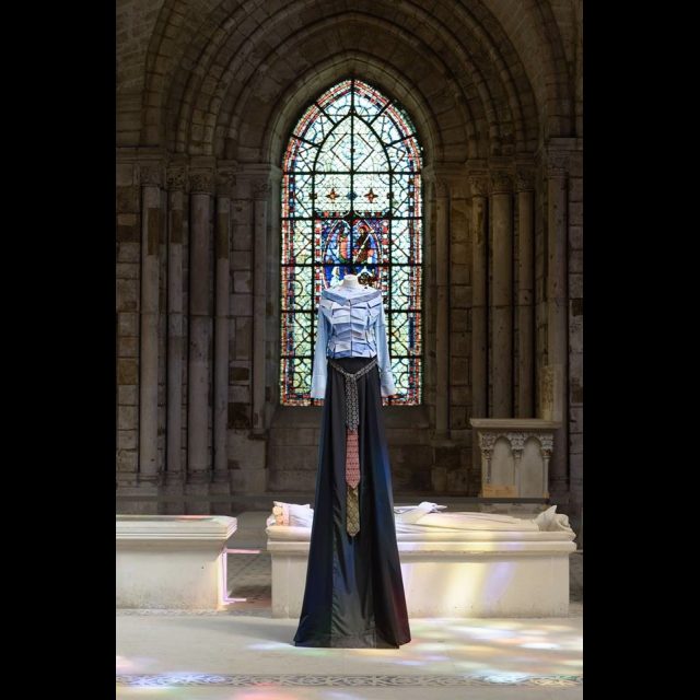 Series: au Grand Robes Royales<br>
Height: 3 m / 9 ft<br>
Installation view, Cathedral of St. Denis, 2016.<br>
The bib is composed of men’s dress shirt collars and cuffs; the woolen dress is made of dark gray men's suit twill and embellished with a belt made up of mens’ neck ties.
Collaboration with Thiphanie Arnaudeau.
Photo: Aiman Saad Ellaoui / Ville de Saint-Denis