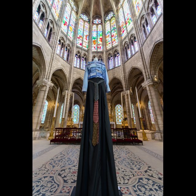 Series: Les Grand Robes Royales<br>
Height: 3 m / 9 ft<br>
Installation view, Cathedral of St. Denis, 2016.<br>
The bib is composed of men’s dress shirt collars and cuffs; the woolen dress is made of dark gray men's suit twill and embellished with a belt made up of mens’ neck ties.
Collaboration with Thiphanie Arnaudeau.
Photo: Aiman Saad Ellaoui / Ville de Saint-Denis