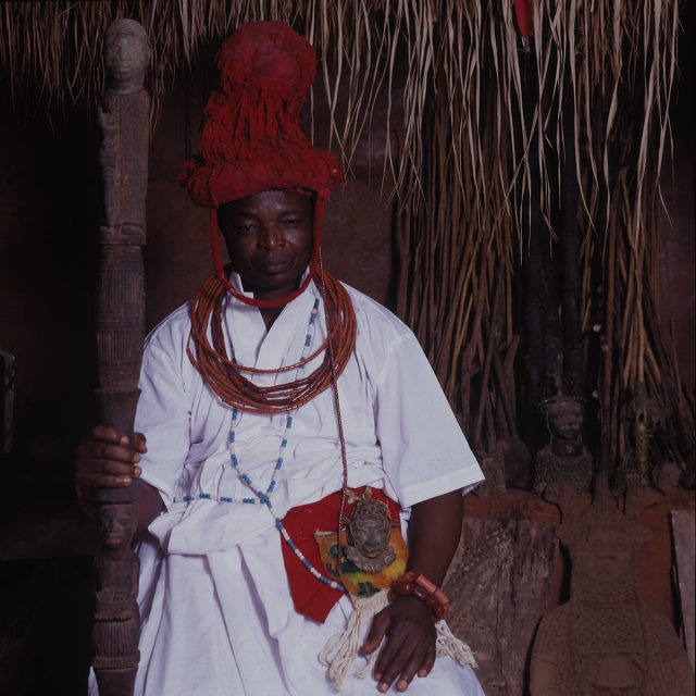 A member of Ihogbe, the king’s priests, this man takes charge of the purification medicine that drives off evil spirits along the path of the king. As a high-ranking official, he is privileged to wear a brass hip mask.
Series: <i>Kings, Chiefs, and Women of Power</i><br>
Chromogenic print on Fujiflex Crystal Archive paper<br>
30” x 30”; Edition: 5 + 2 AP<br>
50” x 50”; Edition: 3 + 1 AP