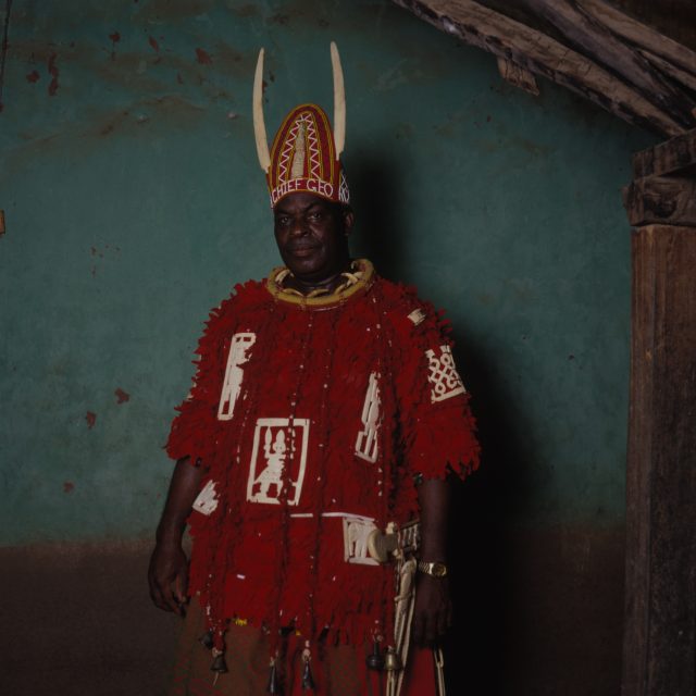 The ceremonial dress called orufaran worn by this war chief is reserved for people of high military rank. The scales of his red velvet tunic represent a pangolin, a type of anteater; because the pangolin curls into a protective ball when attacked, it represents magical protection and success in battle. Themes of the garment’s white appliqued decorations are symbols of power.
Series: <i>Kings, Chiefs, and Women of Power</i><br>
Chromogenic print on Fujiflex Crystal Archive paper<br>
30” x 30”; Edition: 5 + 2 AP<br>
50” x 50”; Edition: 3 + 1 AP